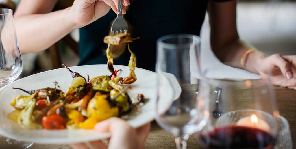 female customer lifting food off a plate with a fork