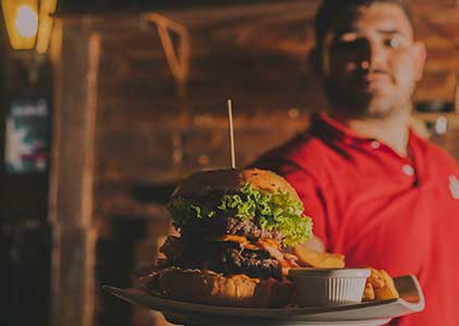 male server with Burger meal on plate