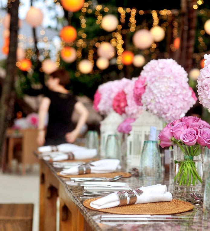 restaurant table setup and ready for a coroporate event with pink flowers in glass vases